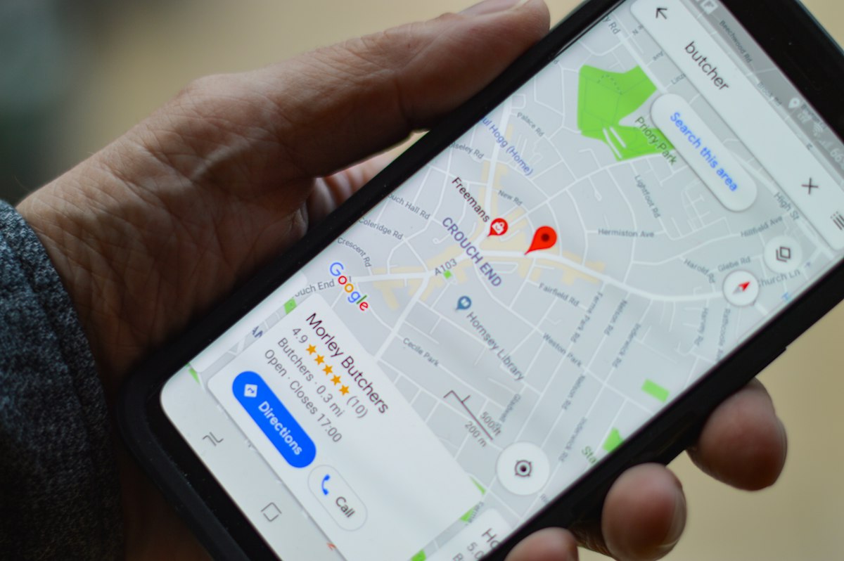 Pessoa segurando smartphone com mapa, ilustrando advogado com perfil no Google Maps