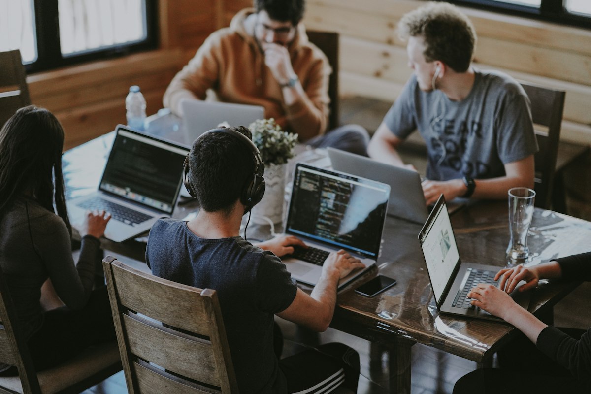 Grupo de pessoas trabalhando em laptops, ilustrando uma agência de marketing para advogados