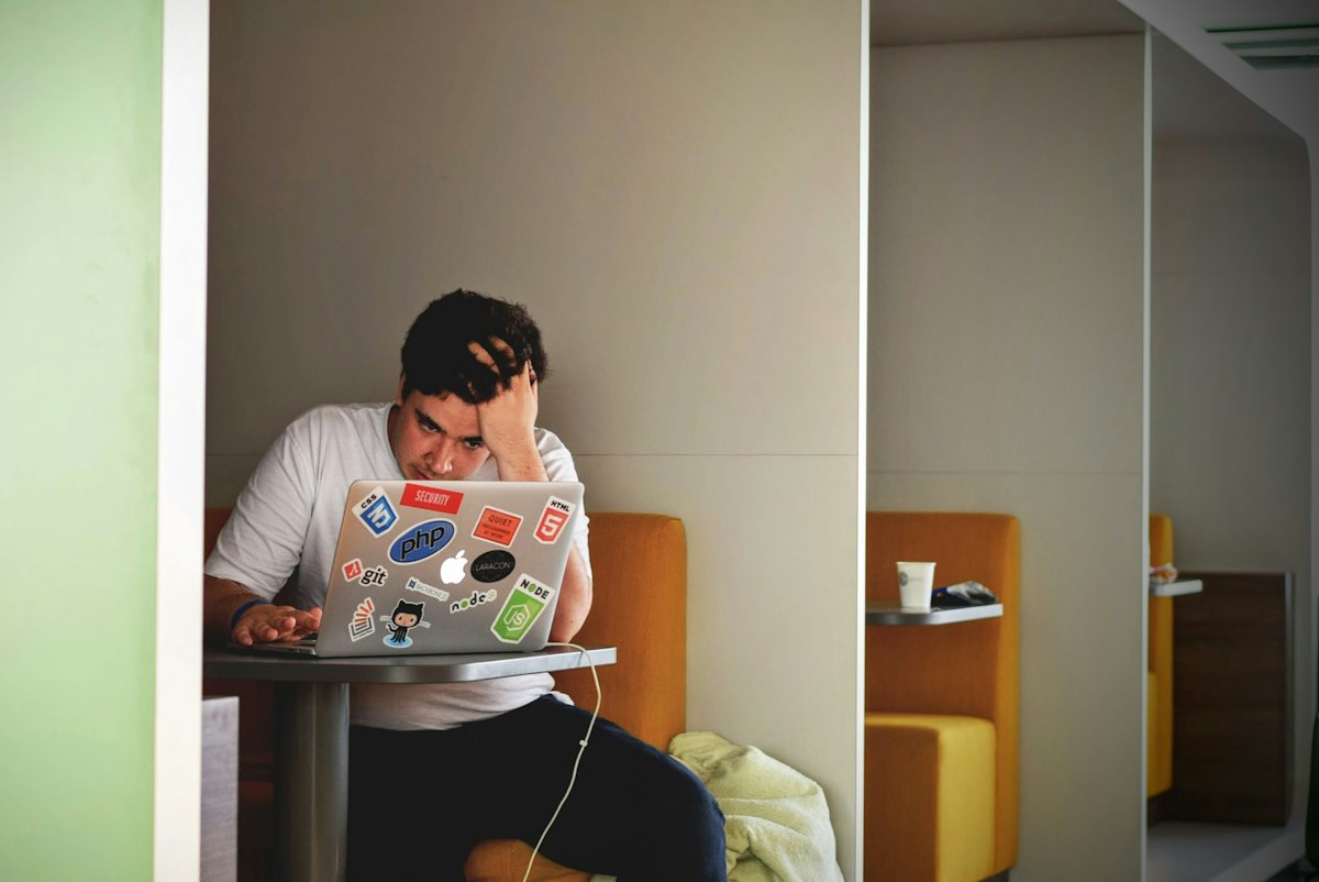 Homem usando laptop com expressão preocupada, ilustrando anúncio reprovado no Google Ads
