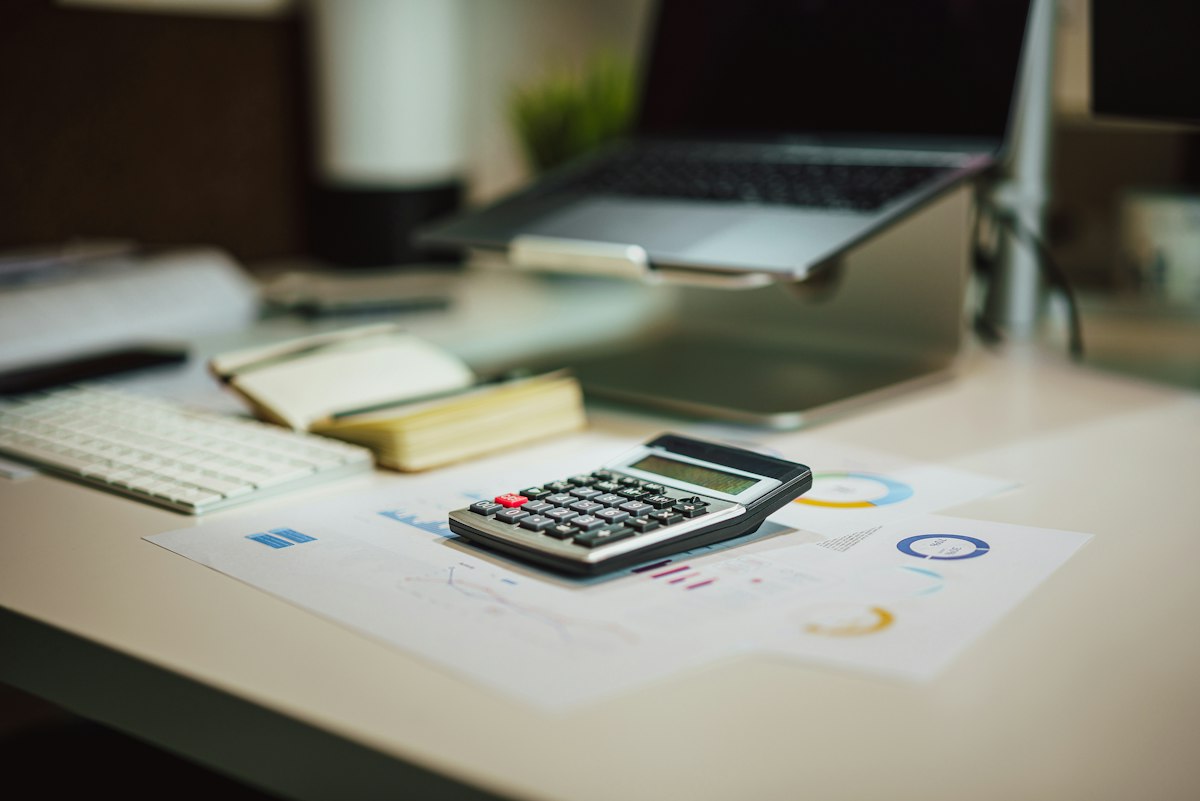 Calculadora ao lado de laptop, ilustrando a calculadora de orçamento de Google Ads para advogados