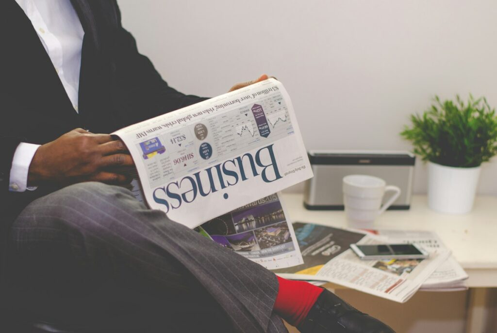 Pessoa lendo jornal à mesa, ilustrando citações online no SEO local da advocacia
