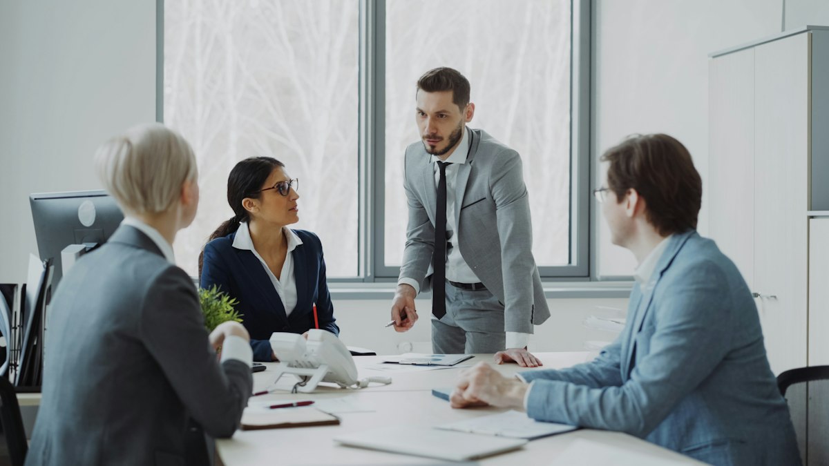 Profissionais em reunião ao redor de mesa, ilustrando como conseguir clientes na advocacia empresarial