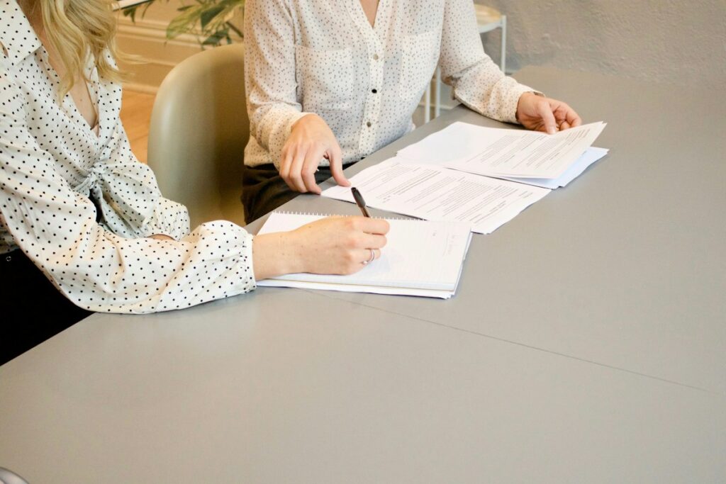 Duas mulheres revisando documentos, ilustrando como divulgar escritório de advocacia