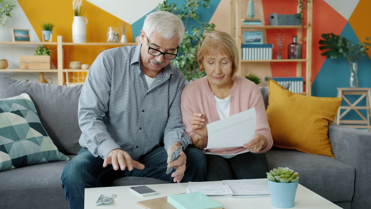 Casal de idosos revisando documentos em casa, ilustrando Google Ads para advogado previdenciário