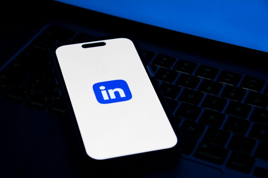 Celular sobre notebook, ilustrando LinkedIn para escritório de advocacia