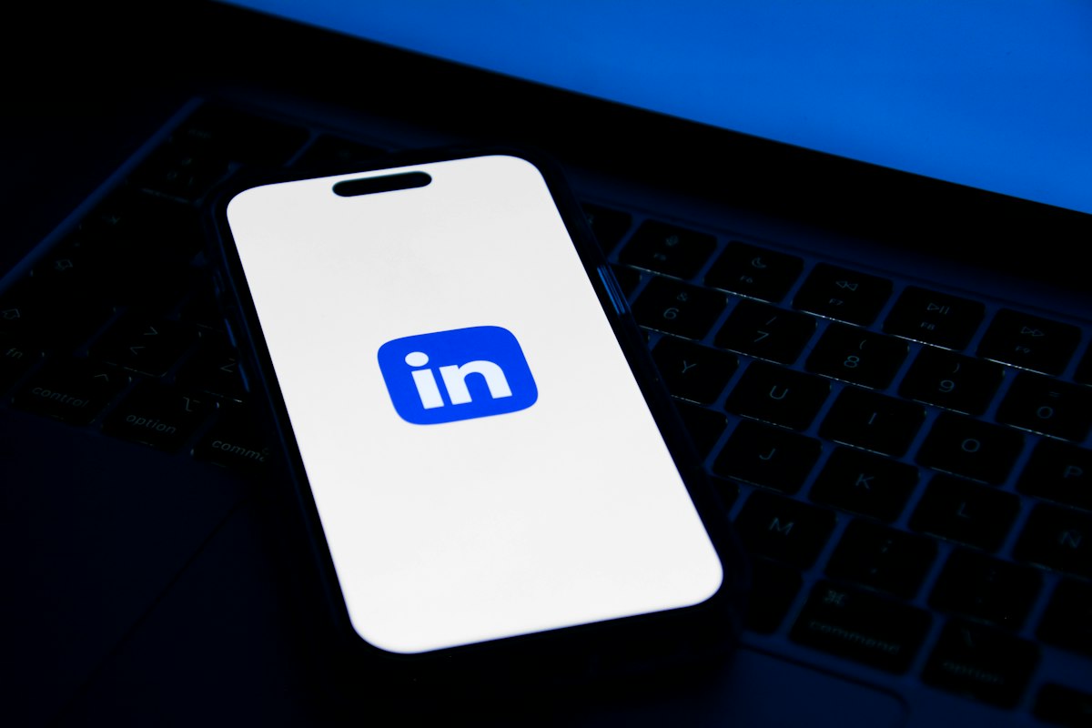 Celular sobre notebook, ilustrando LinkedIn para escritório de advocacia