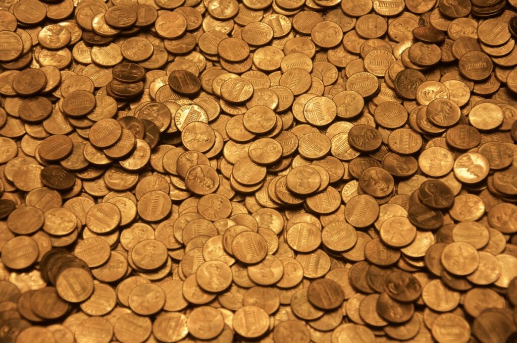 Moedas sobre superfície de madeira, ilustrando quanto custa marketing jurídico