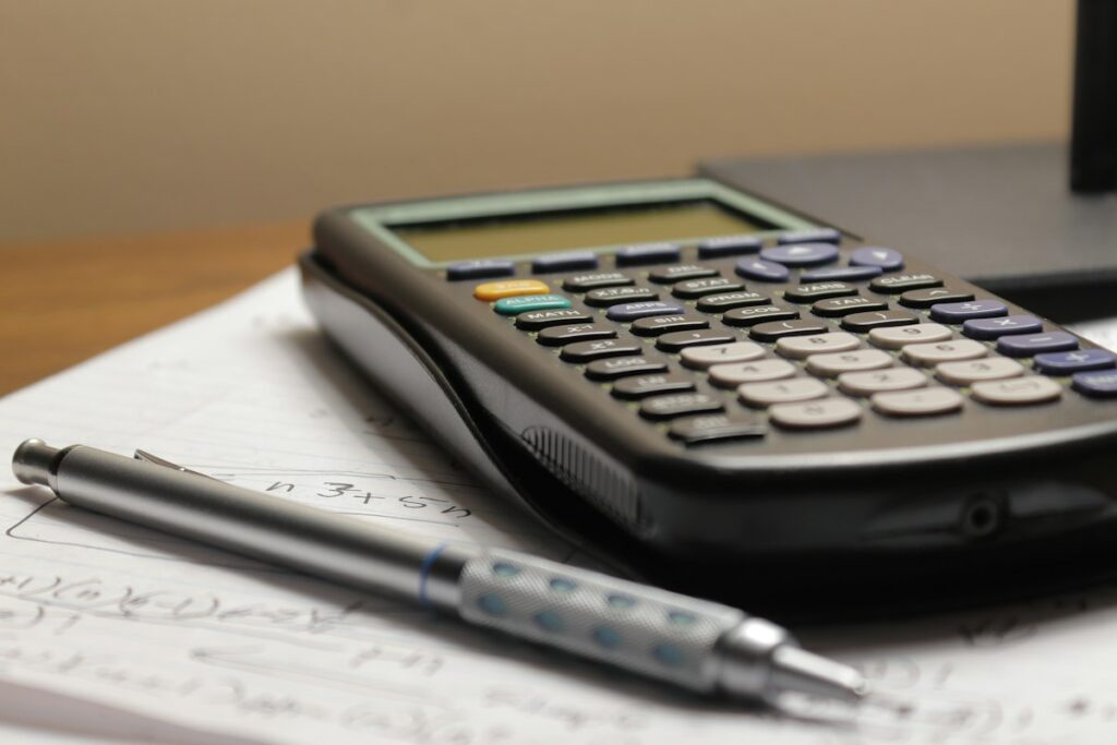 Calculadora e caneta sobre papel, representando quanto custa Google Ads para advogado