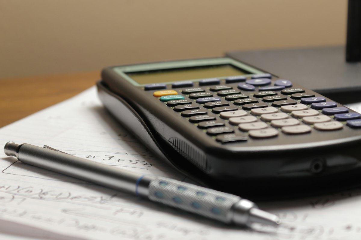 Calculadora e caneta sobre papel, representando quanto custa Google Ads para advogado