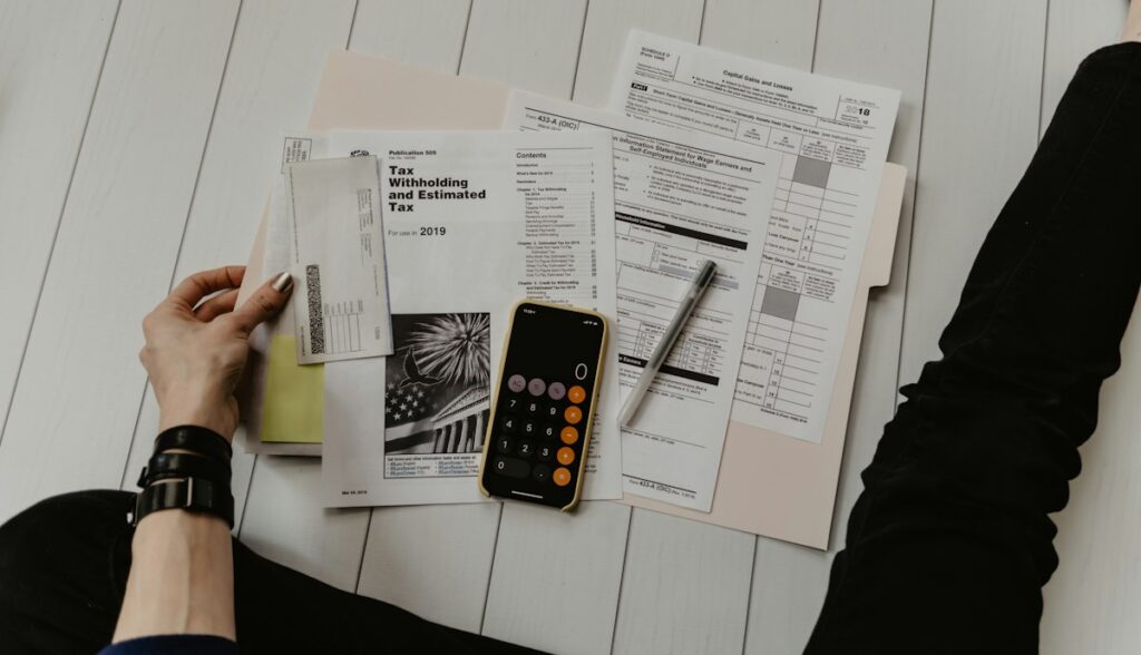 Pessoa segurando papel perto de caneta e calculadora, ilustrando quanto investir em marketing jurídico