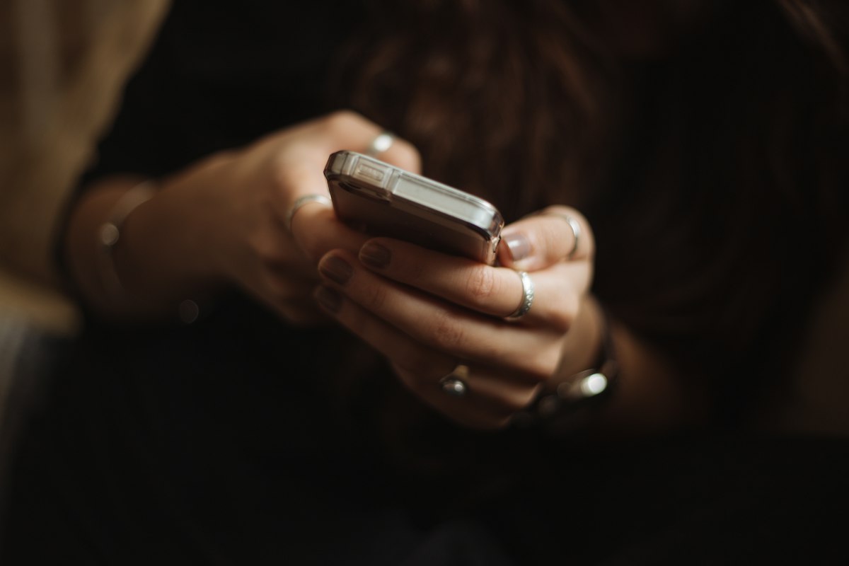 Pessoa usando smartphone para conversar, ilustrando WhatsApp ou formulário no site do escritório